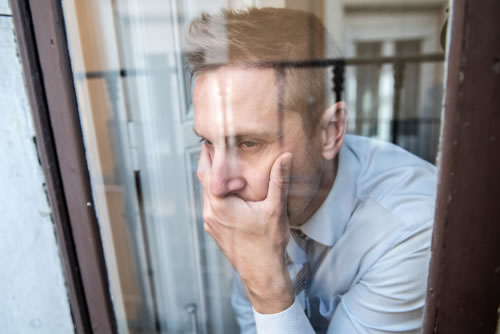 Depressed man looking out of the window