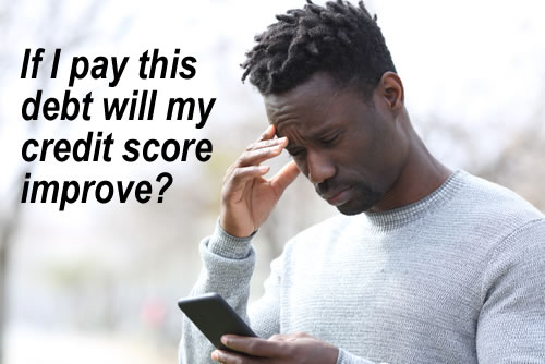 Man looking at his mobile and worring about his credit score - will paying a debt improve it?
