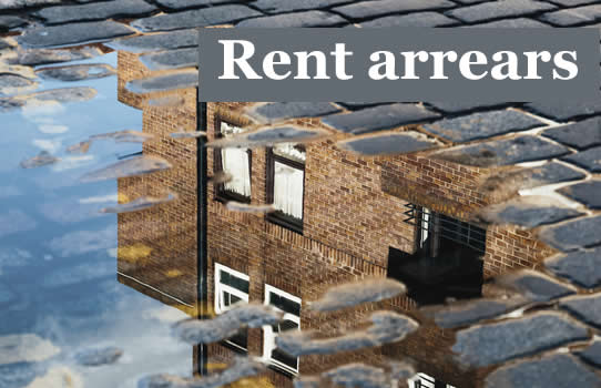 reflaction of some flats in a rain puddle on cobblestones - do you have rent arrears?