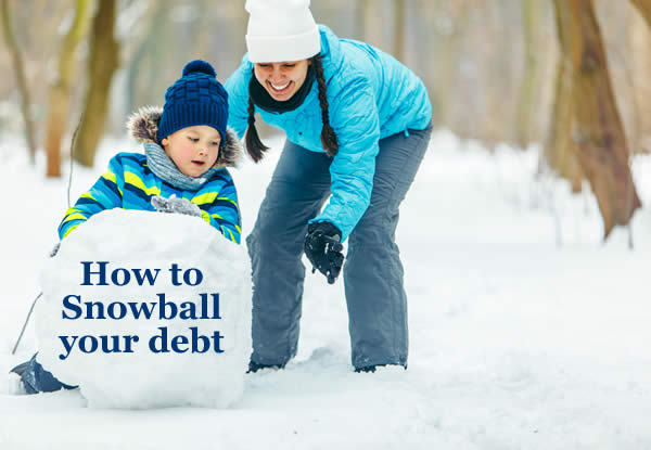 Woman helping a child roll a snowball. A snaowball gets big and rolls fast - and snaowbally your debts will clear them faster.