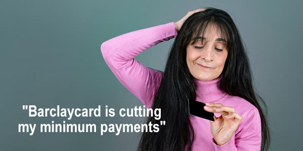 Woman looking at her credit card - Barclaycard is cutting the minimum monthly payments - but this is not good news 